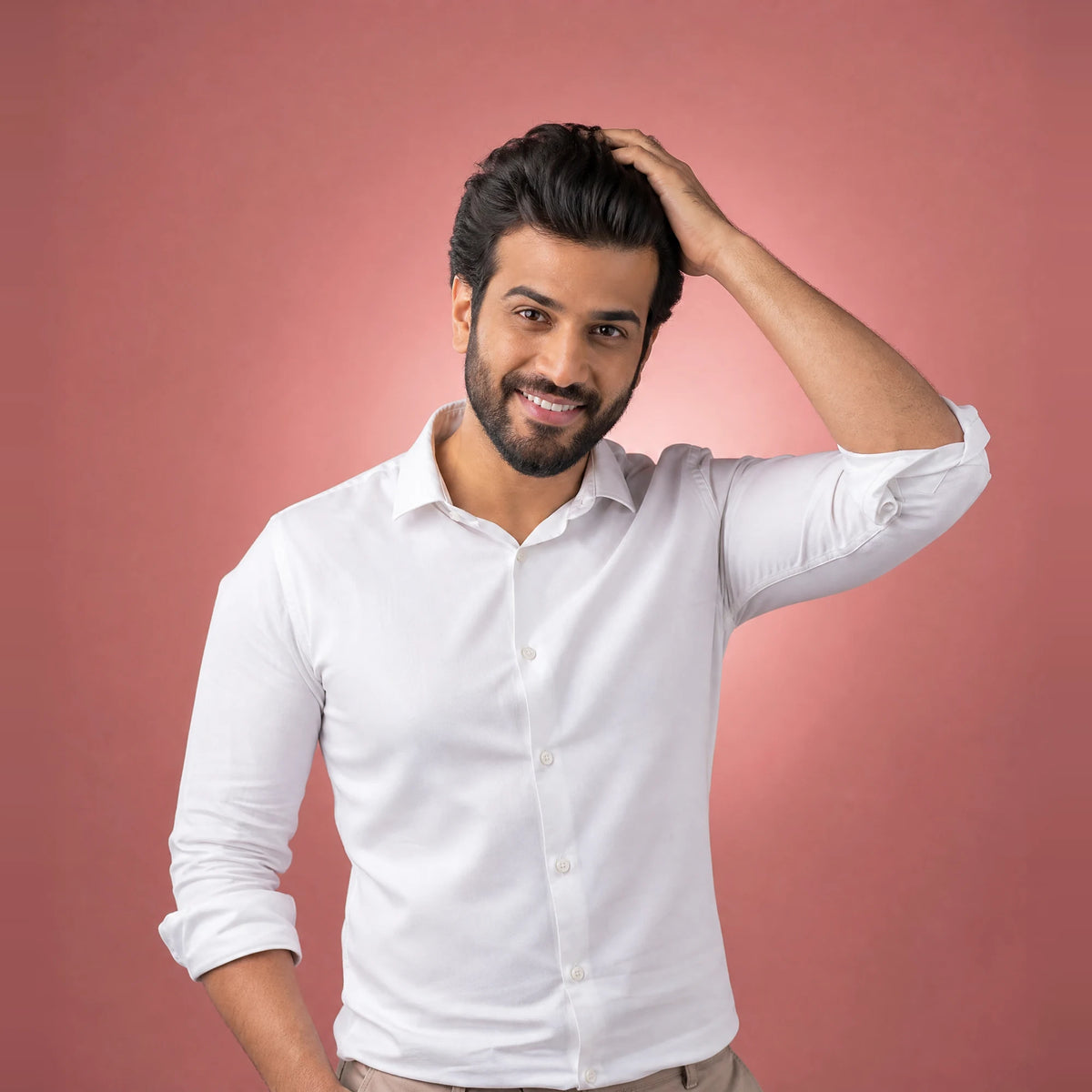Smiling man running a hand through his thick dark hair