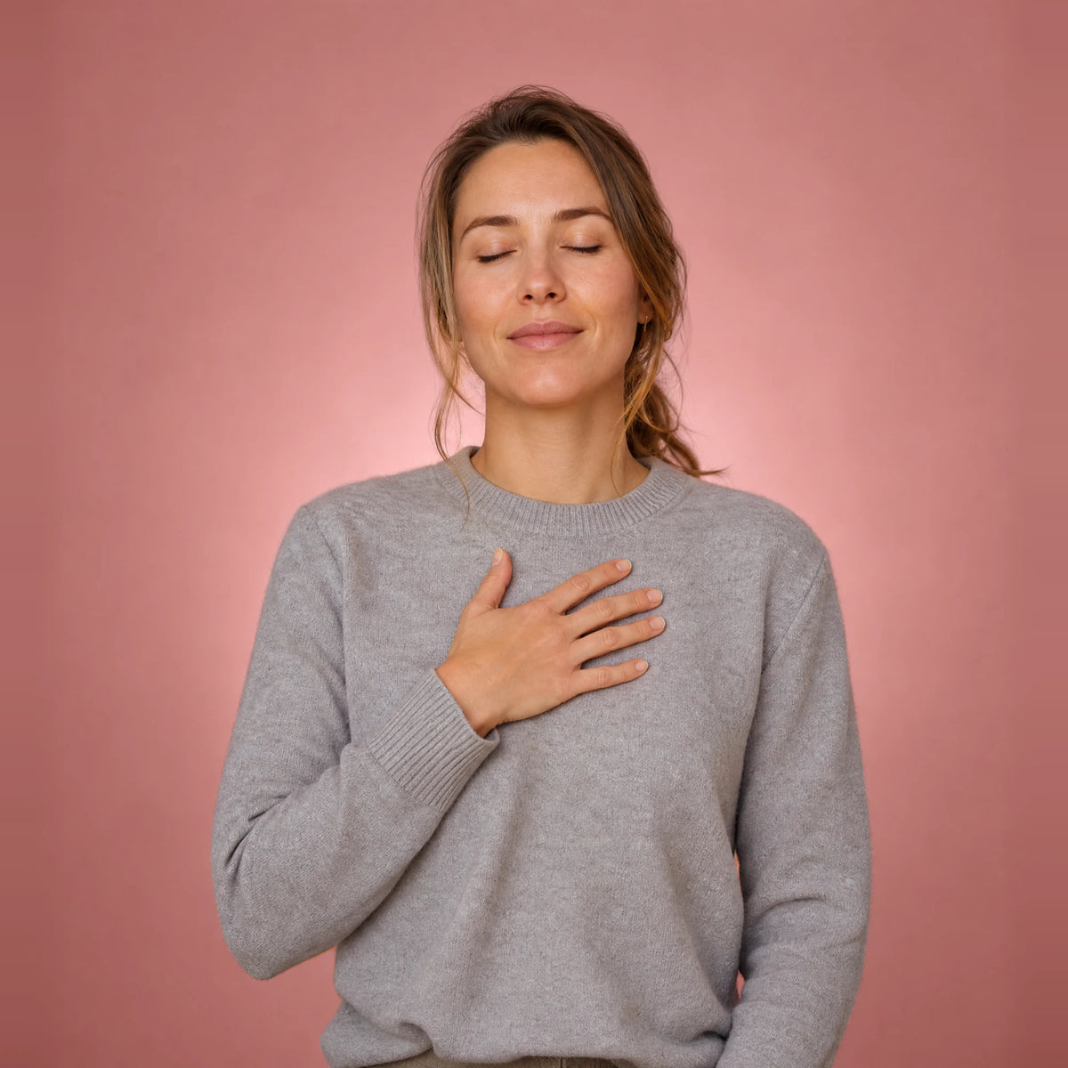 Woman with her eyes closed and a hand on her chest, taking a calm breath